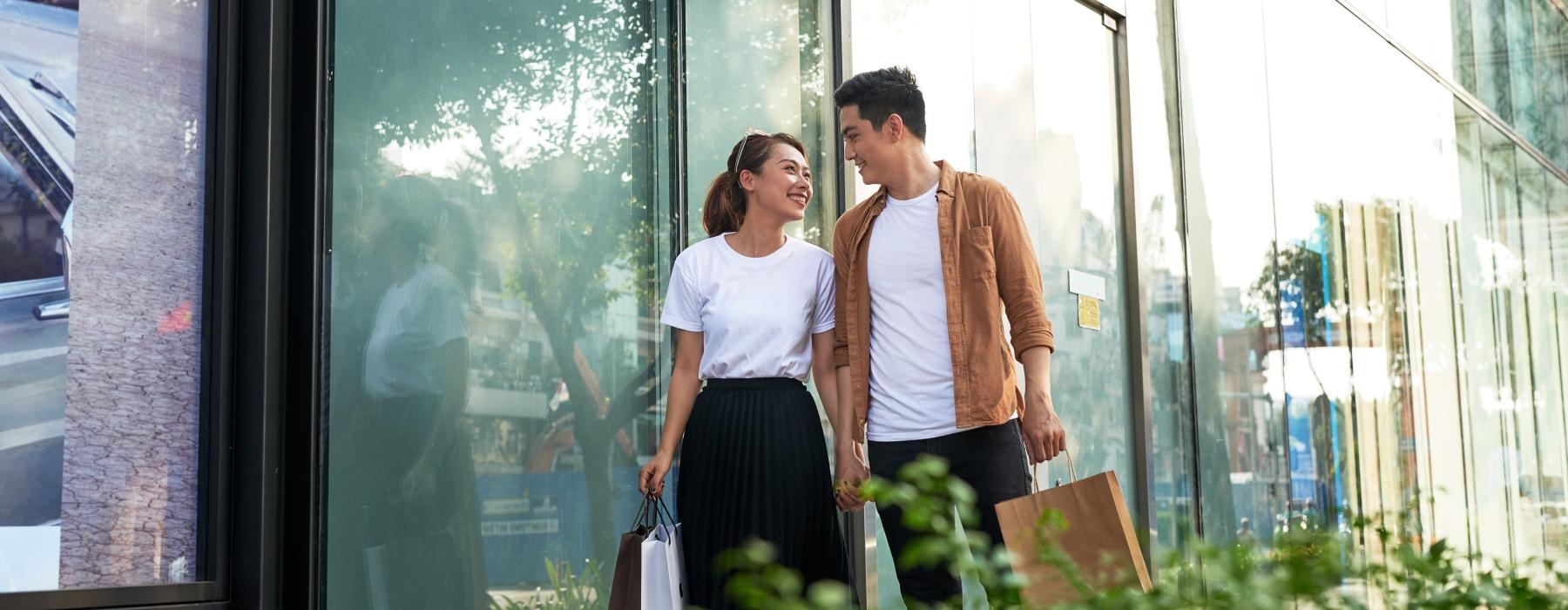 a man and woman standing in front of a glass wall