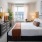 well lit bedroom with bed and dresser 