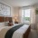 bedroom with a bed and dresser with a plant in the corner