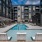 pool with ample seating in front of an apartment building 