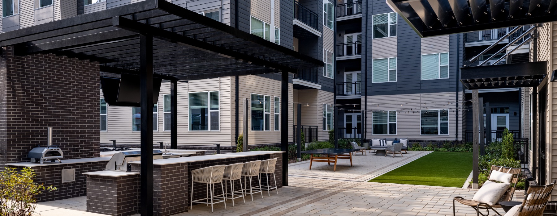 outdoor kitchen with grill and lawn games