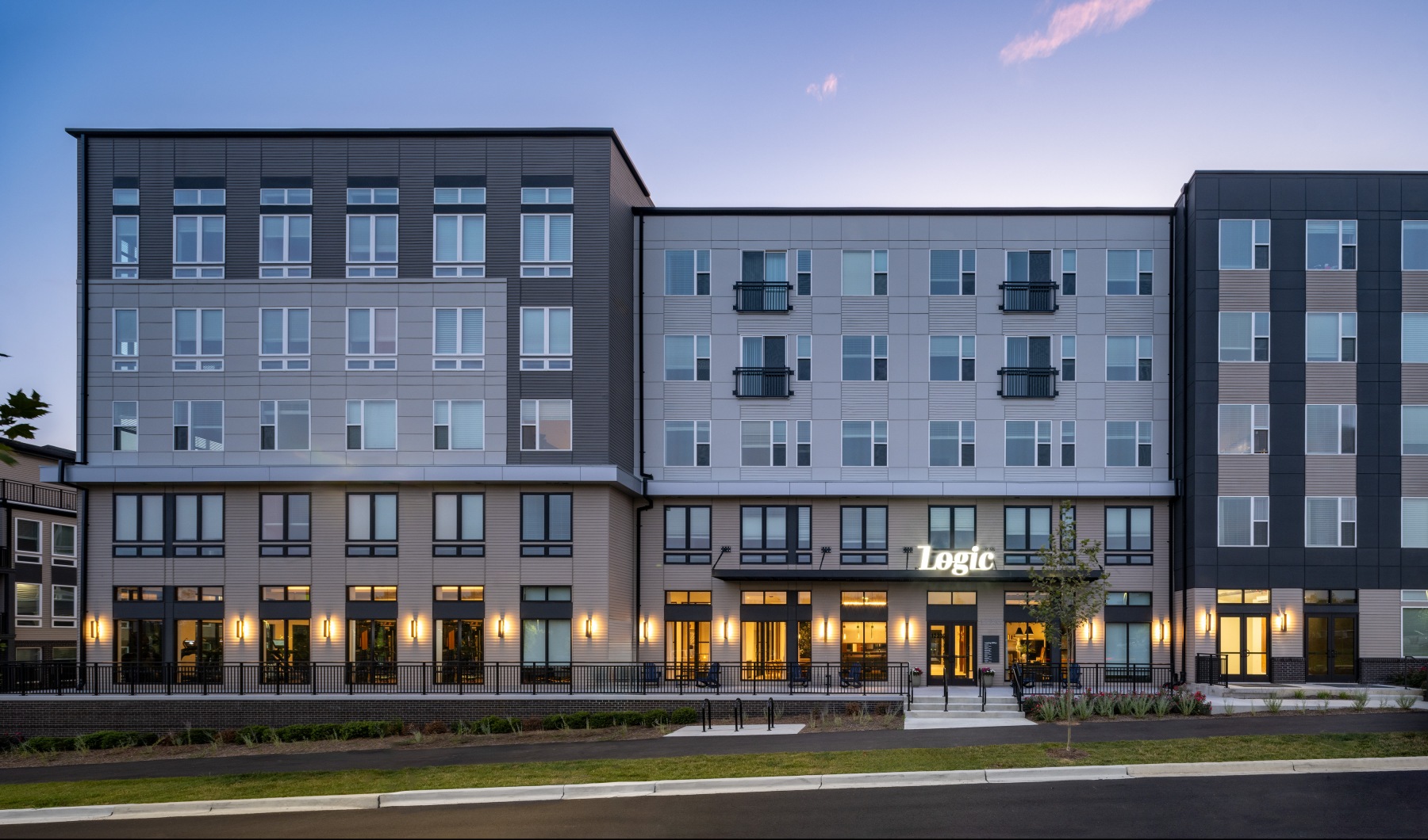 apartment exterior at dusk with a street in front